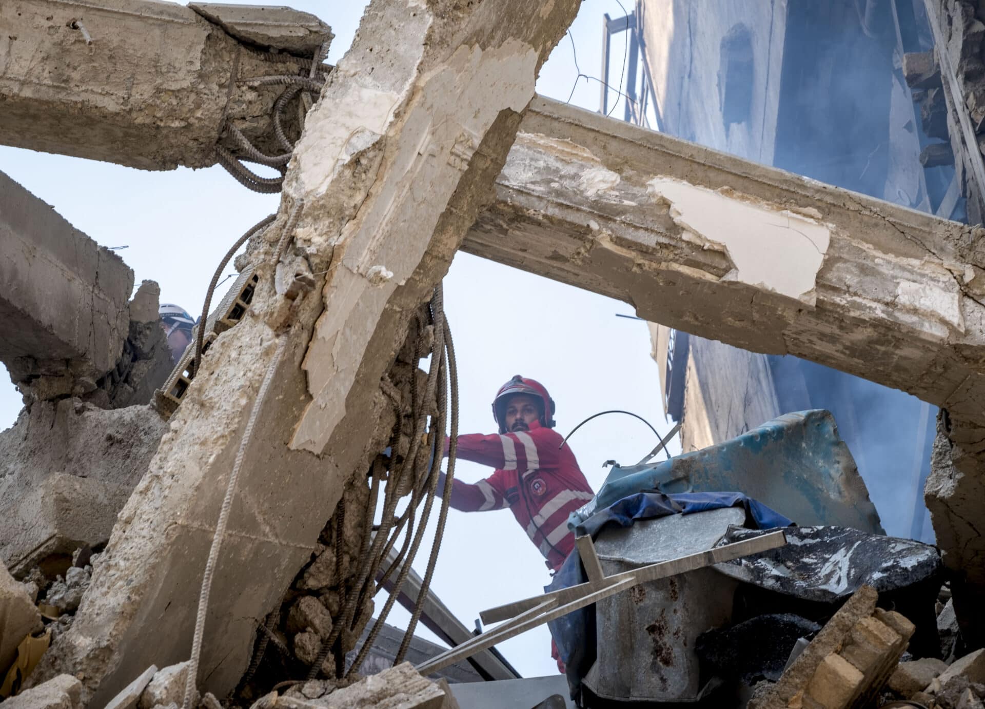 An Iranian firefighter examines rubble of a destroyed residential building in Tehran